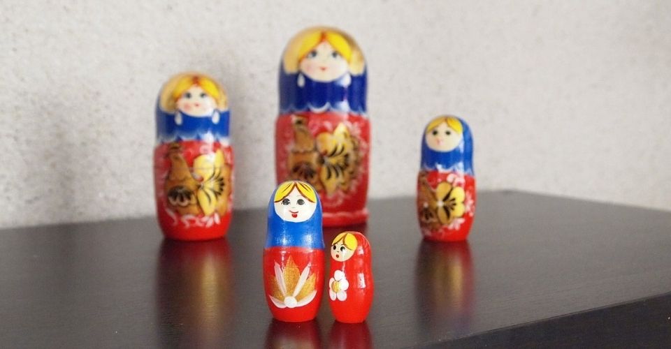 Russische matroesjka-poppen in verschillende maten – symbool voor hoe familielast of rollen soms onbewust worden doorgegeven van generatie op generatie.