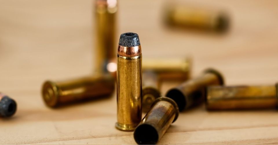 Stapeltje kogels op houten oppervlak – symbool voor scherpe opmerkingen en de impact van woorden in een relatie, passend bij het concept 'catching the bullet'.