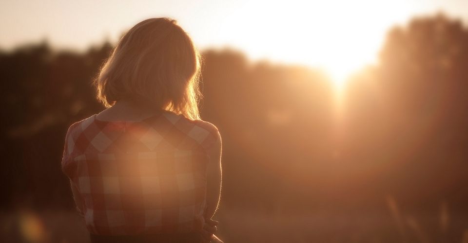 Silhouet van een vrouw in het zonlicht – beeld van innerlijke kracht, grenzen stellen en leven vanuit eigen regie.