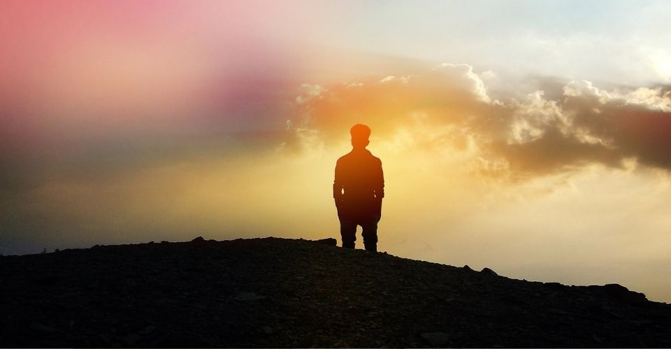 Man kijkt uit over landschap in zacht licht – metafoor voor hoe rouw het verleden mooier kan maken dan het werkelijk was.