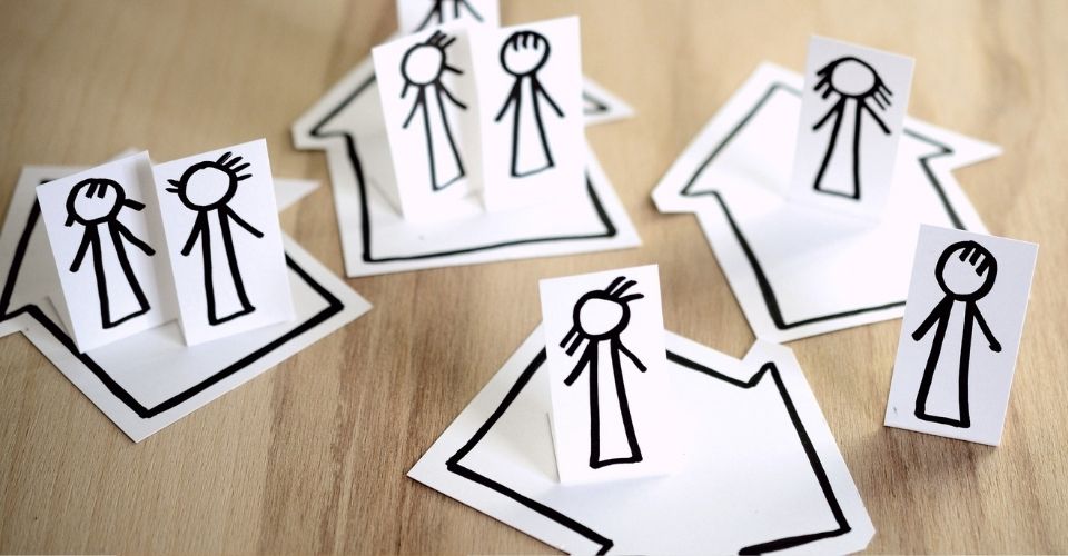 Papieren poppetjes op pijlen en huizen – symbolisch voor familiesystemen en het maken van je eigen keuzes als volwassene.