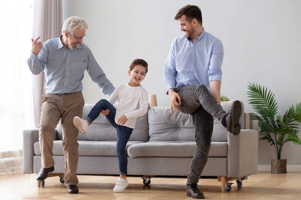 Beeld van een opa, vader en zoon die samen dansen naar aanleiding van een durf opdracht in het gezinsspel Doen Durven of Waarheid Family Fun